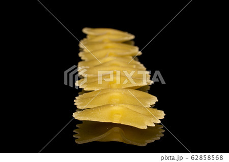 Yellow farfalle pasta isolated on black glass 62858568
