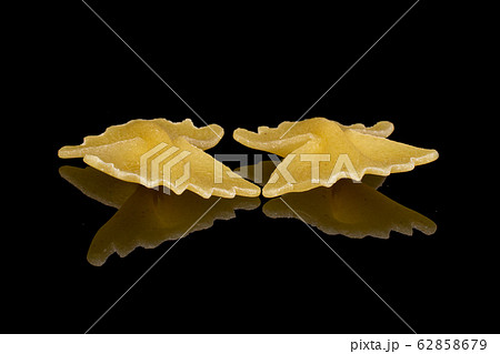 Yellow farfalle pasta isolated on black glass Yellow farfalle pasta isolated on black glass 62858679