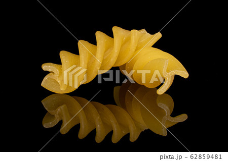 Yellow fusilli pasta isolated on black glass 62859481