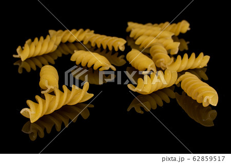 Yellow fusilli pasta isolated on black glass Yellow fusilli pasta isolated on black glass 62859517