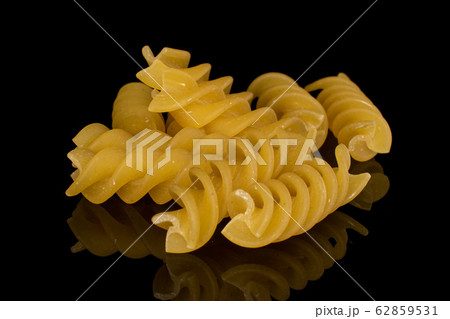 Yellow fusilli pasta isolated on black glass Yellow fusilli pasta isolated on black glass 62859531