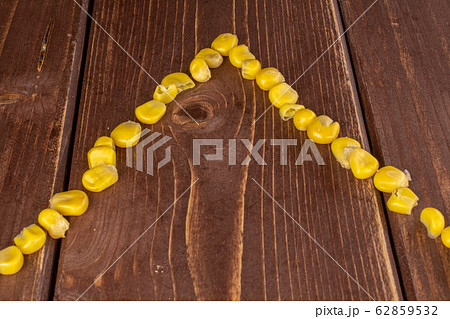 Yellow canned corn on brown wood 62859532
