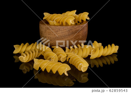 Yellow fusilli pasta isolated on black glass Yellow fusilli pasta isolated on black glass 62859543