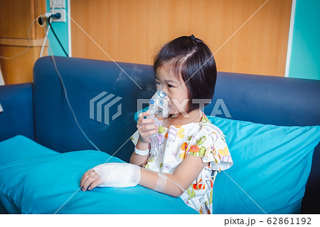 Sad asian child holds a mask vapor inhaler. 62861192