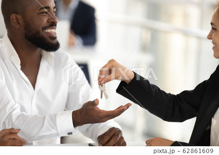 Realtor giving keys to new apartment to african american husband 62861609
