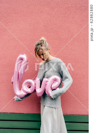 Cute blonde holds a big inflatable word LOVE 62862880