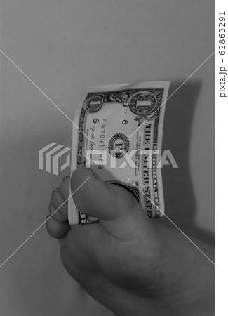 Foot holding a one dollar bill between toes Foot holding a one dollar bill between toes 62863291
