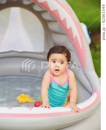 Surprised baby girl in swimming pool 62863349