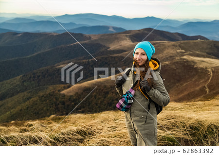 Woman the top of the mounting and looking at a beautiful landscape. Woman with backpack achieving the top the enjoying sunlit. 62863392