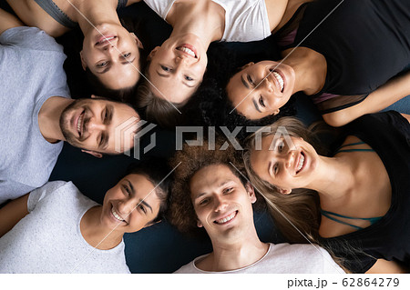 Above view sporty people lying in circle looking at camera 62864279