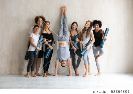 Full length sportive diverse people holding mats standing near wall Full length sportive diverse people holding mats standing near wall 62864301
