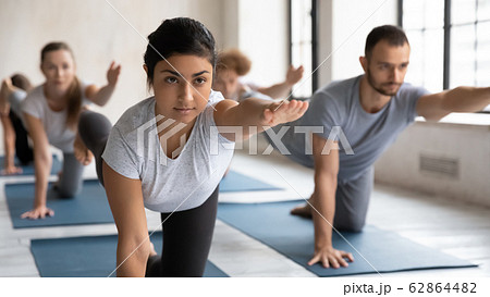 Indian coach and group of people doing Bird Dog Pose Indian coach and group of people doing Bird Dog Pose 62864482