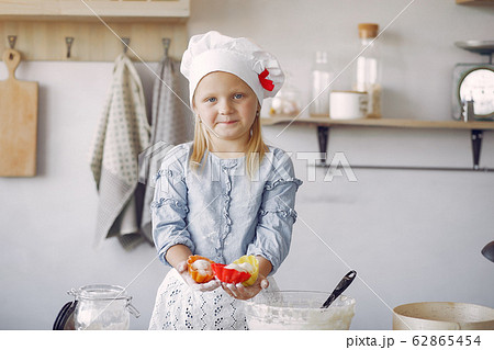 Little girl in a white shef hat cook the dough for cookies 62865454