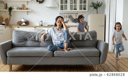 Exhausted young mother annoyed from loud children Exhausted young mother annoyed from loud children 62868028