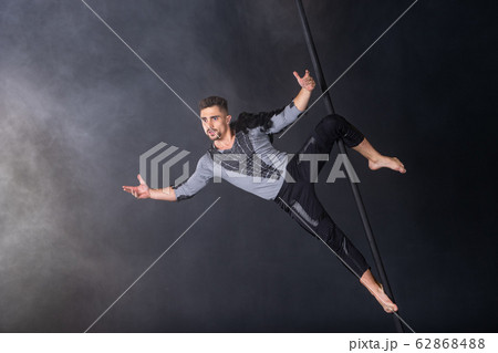 Performance concept. Man hanging on chinese pole. Athlete performing flying pole 62868488