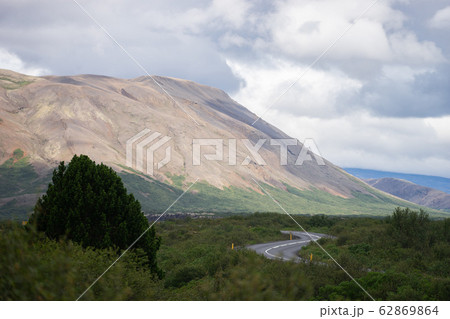 S-curve road near hill with Green tree and sky in Iceland 62869864