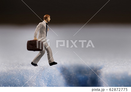 地面の穴と落ちそうなビジネスマン 62872775