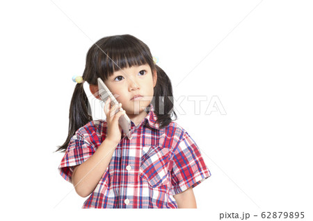真剣な顔でスマートフォンで話をする幼い女の子。スマートフォン、相談、悩み、電話イメージ 62879895