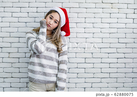 Young woman in costume Christmas on white brick 62880075