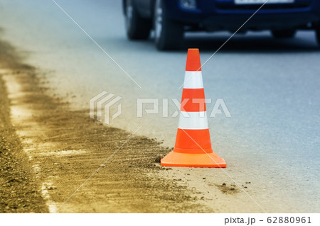 Warning traffic road cone stand on asphalt city road during roadworks 62880961