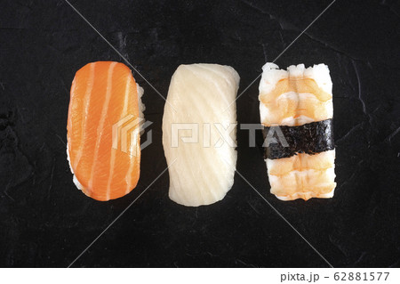 Nigiri sushi set, close-up overhead shot on a black background. Fresh salmon, white fish, and shrimp on rice Nigiri sushi set, close-up overhead shot on a black background. Fresh salmon, white fish, and shrimp on rice 62881577
