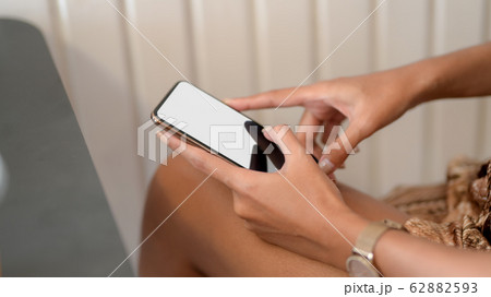 Side view of female using smartphone on her lap 62882593