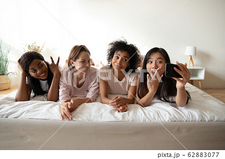 Beautiful Asian woman taking selfie with friends at sleepover party Beautiful Asian woman taking selfie with friends at sleepover party 62883077