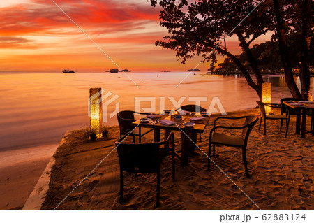 Romantic sunset on the shore of a tropical island. Cafe on the beach. 62883124