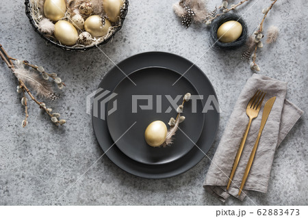 Easter table setting with black and golden decor 62883473