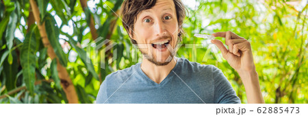 Man placing a bite plate in his mouth to protect his teeth at night from grinding caused by bruxism 62885473