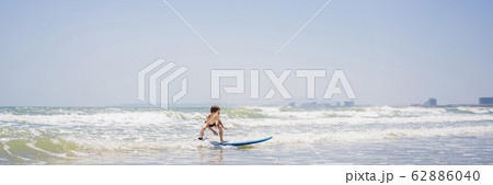 Healthy young boy learning to surf in the sea or ocean BANNER, LONG FORMAT Healthy young boy learning to surf in the sea or ocean BANNER, LONG FORMAT 62886040