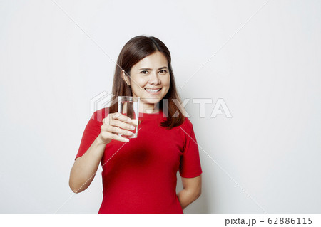 Young beautiful woman drinks water from a glass 62886115