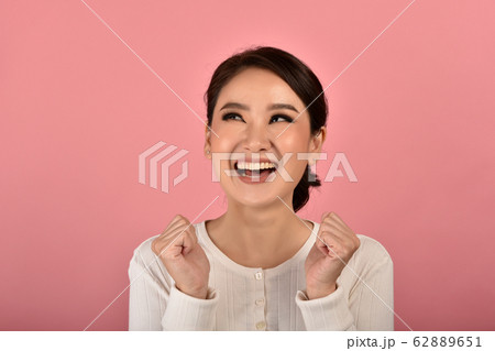 Happy asian woman feeling excited on accomplish success on pink background. 62889651
