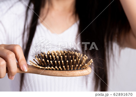 Healthy concept. Woman show her brush with damaged hair Healthy concept. Woman show her brush with damaged hair 62891670