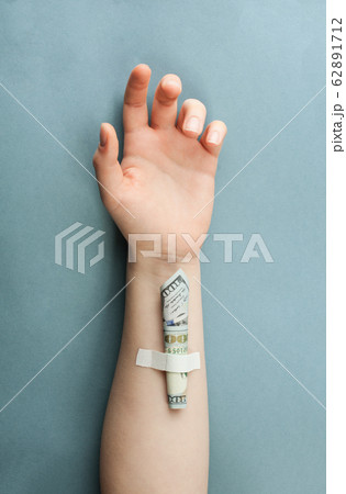 Human hand with 100 US Dollars banknote on vein Human hand with 100 US Dollars banknote on vein 62891712