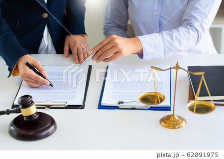 Women lawyer discussing with clients in courtroom. Women lawyer discussing with clients in courtroom. 62891975