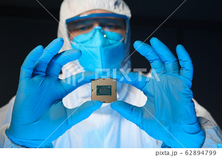 Man in special uniform shows microprocessor chip Man in special uniform shows microprocessor chip 62894799