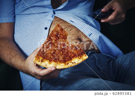 man with a beer belly eating pizza man with a beer belly eating pizza 62895381