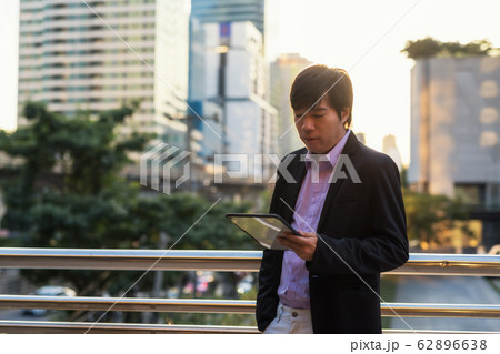 Businessman work on tablet outside office at Businessman work on tablet outside office at 62896638