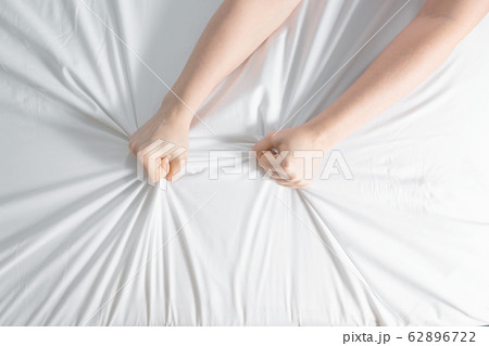 Insomnia concept. Woman's hands on white sheet. Insomnia concept. Woman's hands on white sheet. 62896722
