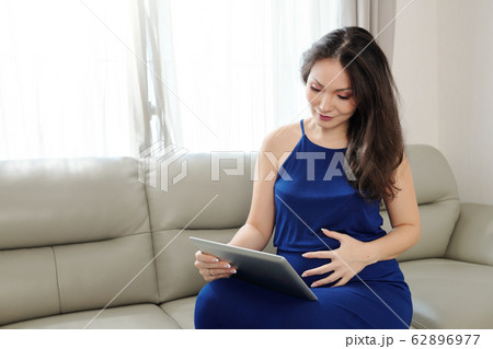 Pregnant woman with tablet computer 62896977