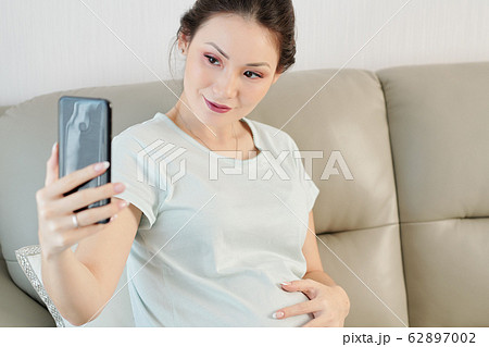 Pregnant woman taking selfie Pregnant woman taking selfie 62897002