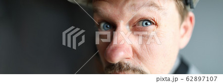 Suspicious male worker trying to see something 62897107