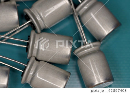 電子部品、銀色の電解コンデンサ（基板背景） 62897403