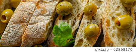 Baguette stuffed with olives, cut with fresh green 62898170