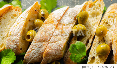 Baguette stuffed with olives, cut with fresh green 62898173
