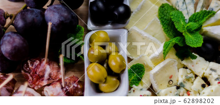 Green olives served with a variety of cheeses and Green olives served with a variety of cheeses and 62898202