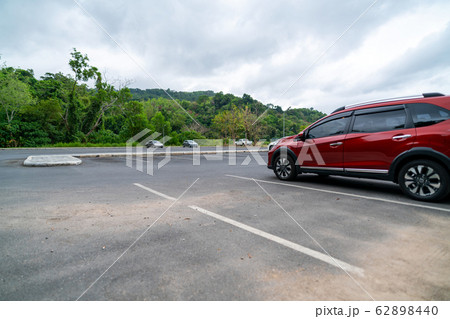 Red suv car parked on concrete parking area 62898440