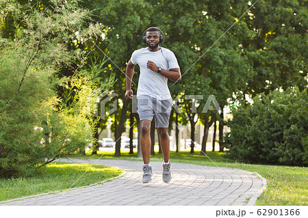 Athletic black guy exercising in public park Athletic black guy exercising in public park 62901366