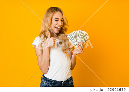 Cashback. Excited woman holding money banknotes and showing thumb up 62901636